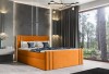 Modernes Polsterbett in Orange in einem Schlafzimmer mit großem Fenster und Waldblick.
