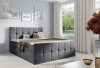 Modernes Boxspringbett in Grau mit gestepptem Kopfteil in hellem Schlafzimmer.