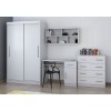Set aus weißem Schrank, Schreibtisch und Kommode vor einer geometrisch gemusterten Wand.