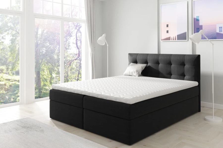 Schwarzes Boxspringbett mit gestepptem Kopfteil und weißem Topper in modernem Schlafzimmer.