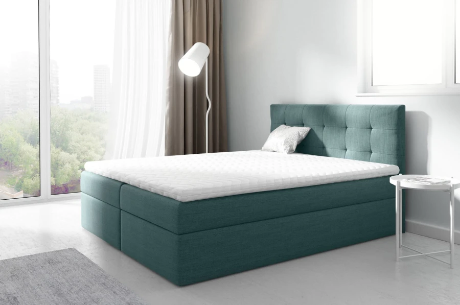 Modernes Boxspringbett in Petrol mit gestepptem Kopfteil im Schlafzimmer-Ambiente.