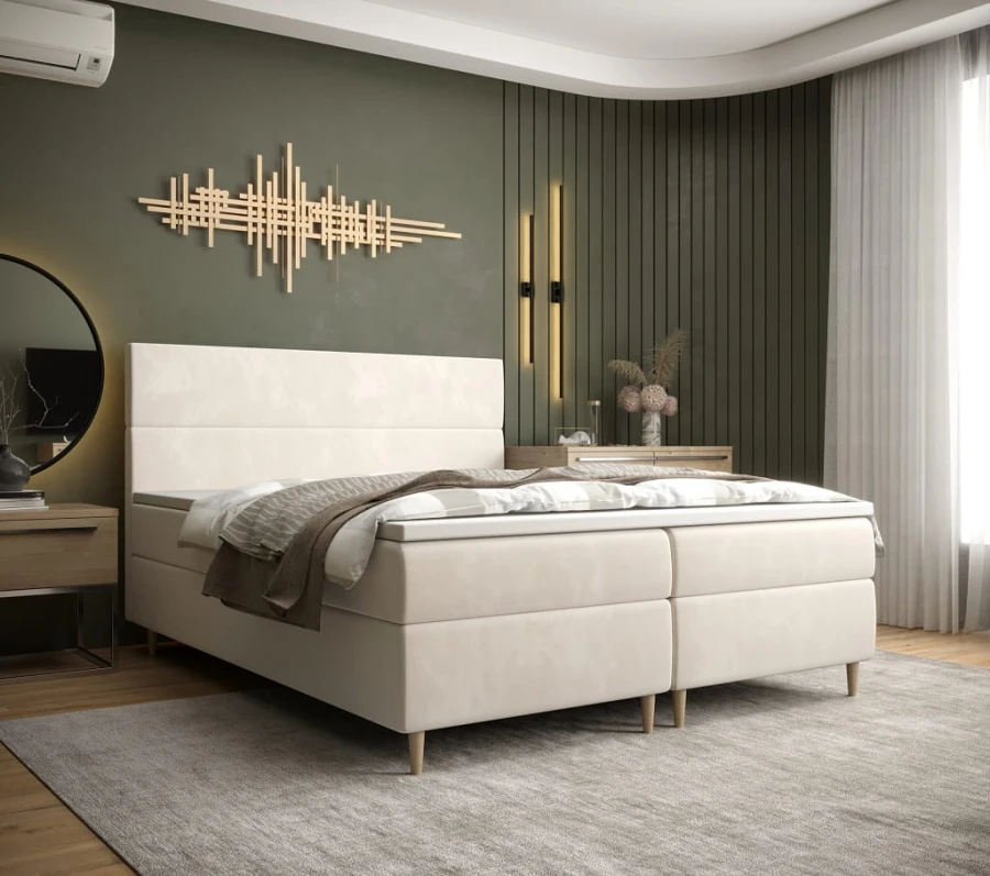 Beiges Boxspringbett in elegantem Schlafzimmer mit olivegrüner Wand und stilvoller Deko