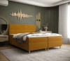 Senfgelbes Boxspringbett in modernem Schlafzimmer mit grüner Wand und Wandkunst