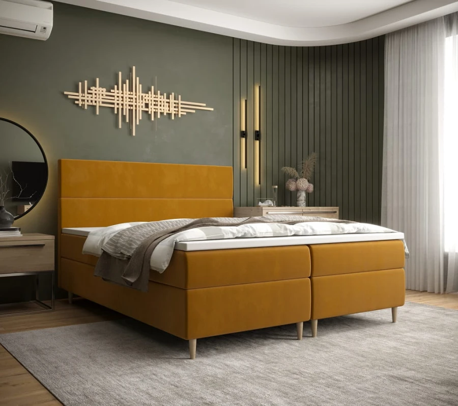 Senfgelbes Boxspringbett in modernem Schlafzimmer mit grüner Wand und Wandkunst