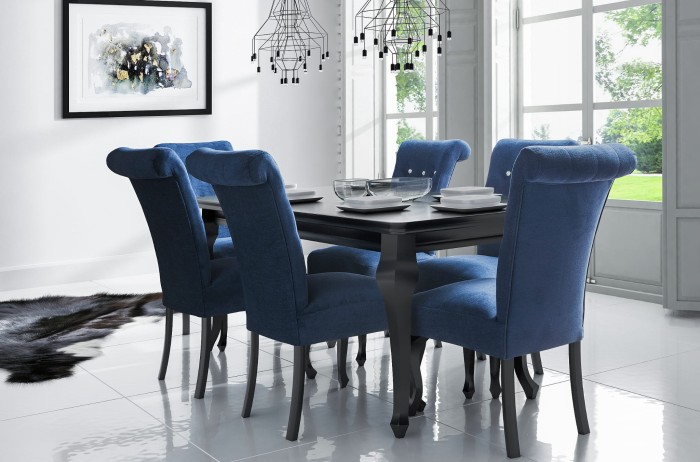 Moderne Essgruppe mit schwarzem Esstisch und sechs blauen Polsterstühlen aus Samt im hellen Raum.