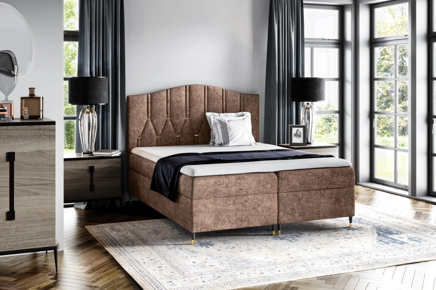 Modernes Boxspringbett in Braun mit elegantem Kopfteil und schwarzen Füßen.