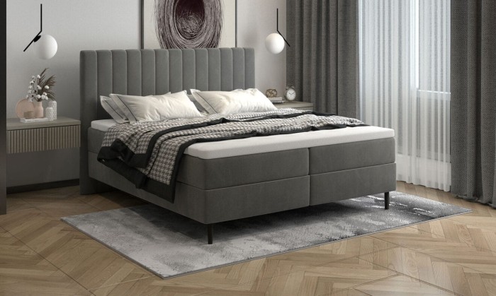 Modernes graues Boxspringbett mit hohem Kopfteil und gemütlicher Bettwäsche im Schlafzimmer.