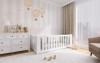 Modernes weißes Kinderbett im hellen Babyzimmer mit kuscheligen Plüschtieren und Deko.
