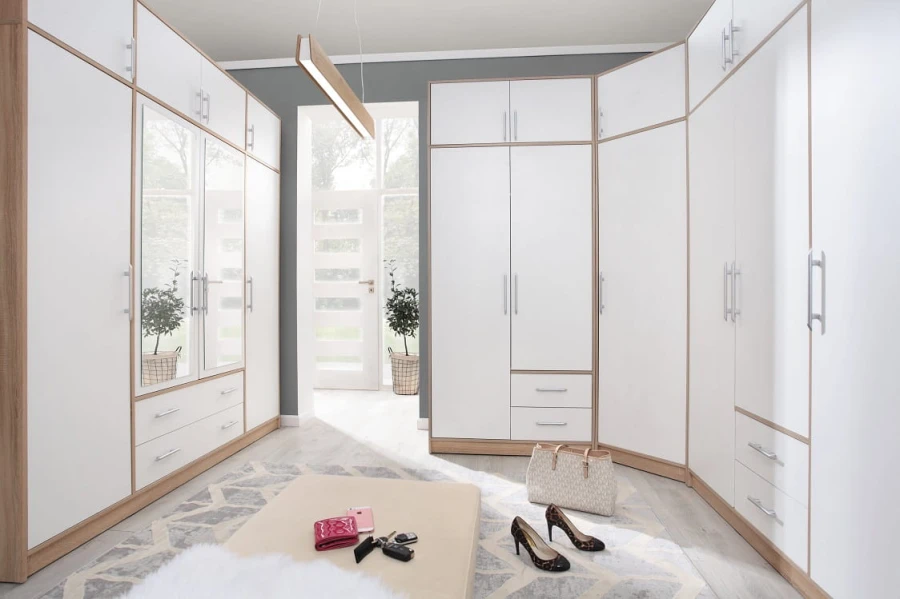 Modulares Schranksystem in Weiß und Eiche für ein begehbares Ankleidezimmer.