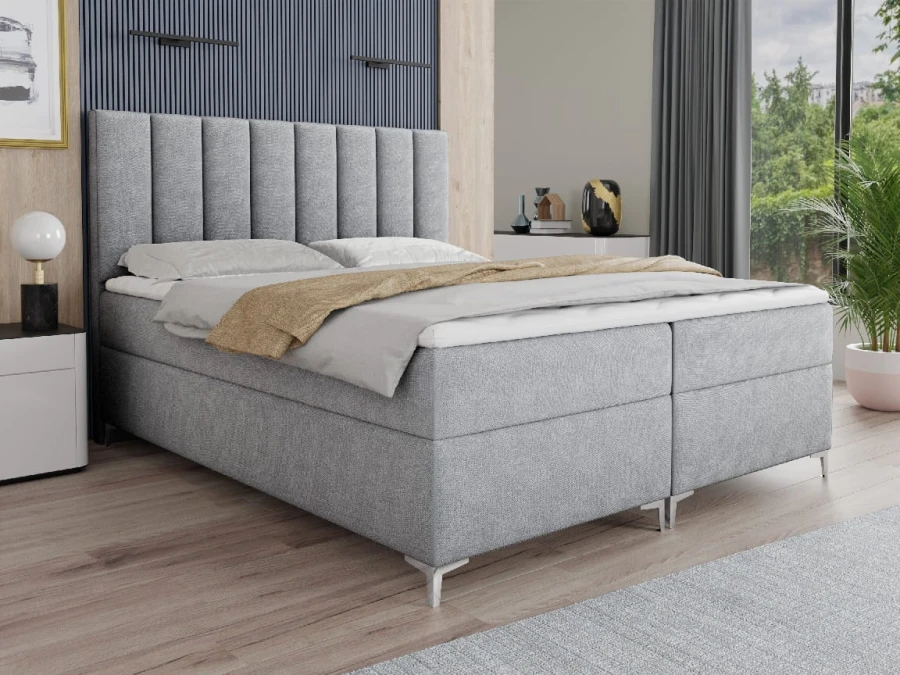 Modernes hellgraues Boxspringbett mit hohem gepolstertem Kopfteil für das Schlafzimmer.