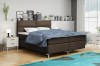 Braunes Boxspringbett mit blauer Decke im modern eingerichteten Schlafzimmer.