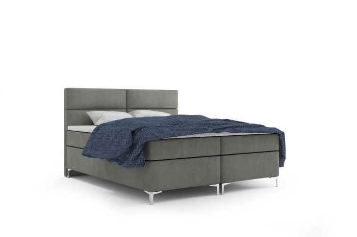 Modernes Boxspringbett in Grau mit blauer Decke auf weißem Hintergrund.