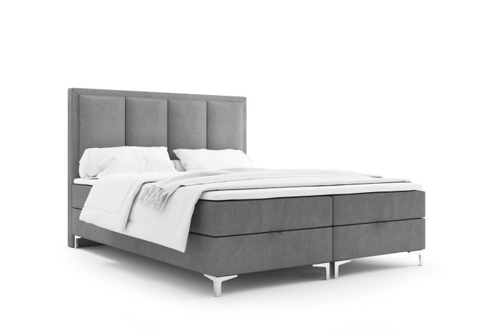 Freigestelltes graues Boxspringbett mit hohem Kopfteil und weißer Bettwäsche.