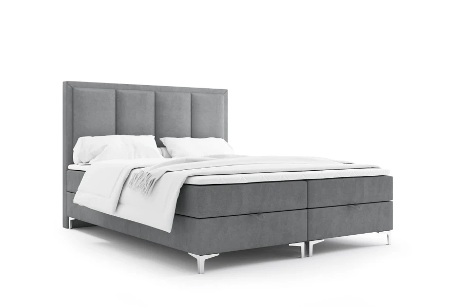 Freigestelltes graues Boxspringbett mit hohem Kopfteil und weißer Bettwäsche.