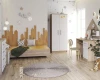 Lichte kinderkamer met houten bed in skyline-look, witte kledingkast en bureau.