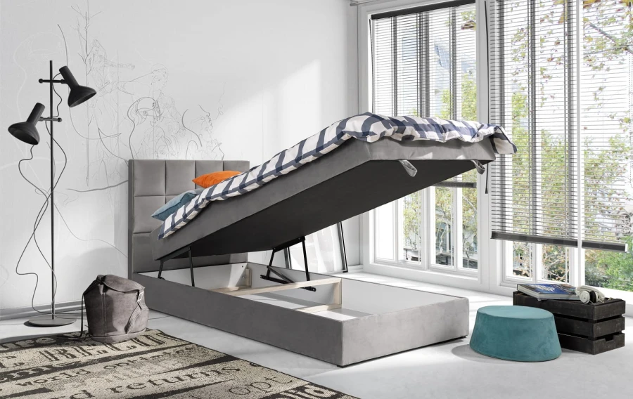 Graues Boxspring-Einzelbett mit offenem Bettkasten für praktischen Stauraum.