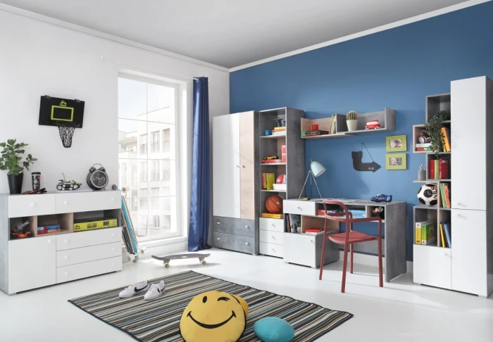 Modernes Jugendzimmer mit blauem Akzent, Schreibtisch und viel Stauraum in Weiß und Grau.