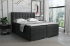 Dunkelgraues Boxspringbett mit gestepptem Kopfteil und gemütlicher Ausstattung für das Schlafzimmer.