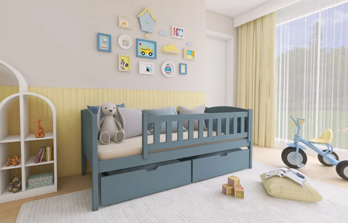 Blaues Kinderbett mit Rausfallschutz und zwei geräumigen Schubladen in einem hellen Kinderzimmer.