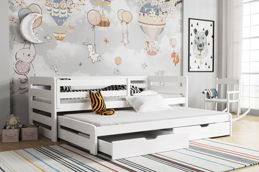Wit kinderbed met logeerbed en opbergladen in een moderne kinderkamer.