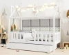 Weißes Kinderbett in Hausform mit Lichterkette und gemütlichen Wandpaneelen.
