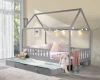 Gemütliches graues Hausbett mit Lichterkette und rosa Dekoration im hellen Kinderzimmer.