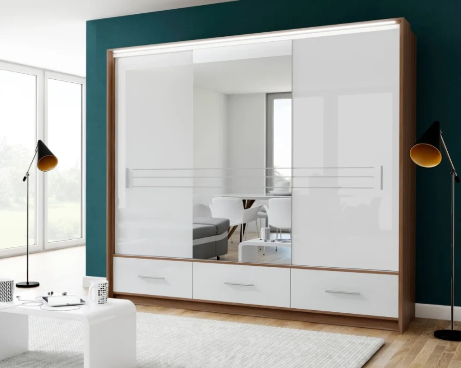 Dreitüriger Kleiderschrank mit Spiegel, weißen Schiebetüren und drei Schubladen im Raum.