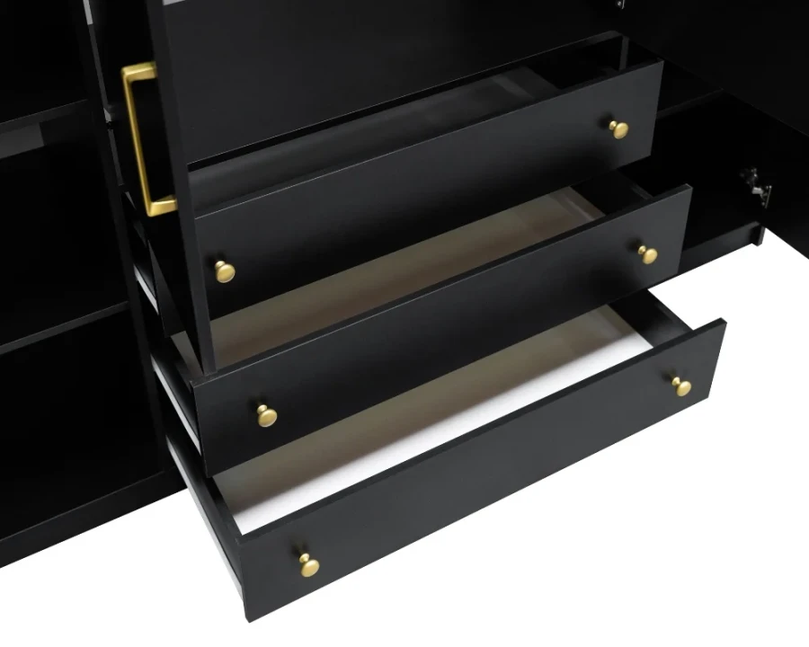 Drei geöffnete schwarze Schubladen mit eleganten goldenen Knöpfen im Detail.