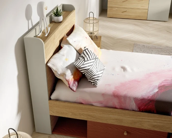 Detailansicht Kopfteil eines Bettes mit Ablagefläche, Deko und modernen Kissen.