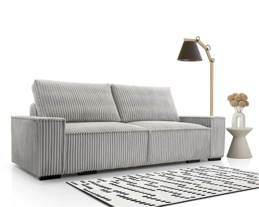 Hellgraues Cordsofa im modernen Design mit Cord-Bezug, Stehlampe und gemustertem Teppich.