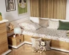 Kuschelige Ecke im Kinderzimmer mit Bett, Holz-Nachttisch und Wanddeko.