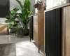Detailansicht eines Sideboards in Holzoptik mit moderner, schwarz gerillter Fronttür.
