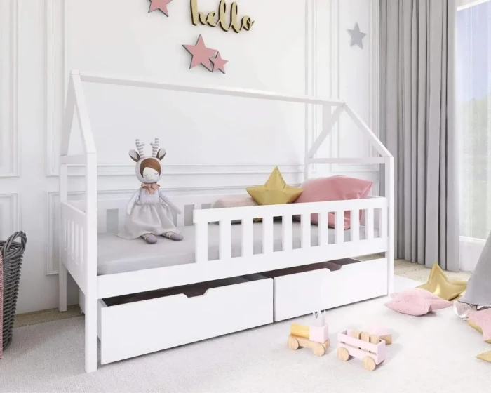 Weißes Kinder-Hausbett aus Holz mit Bettkasten und Rausfallschutz, dekoriert mit Kissen und Spielzeug.
