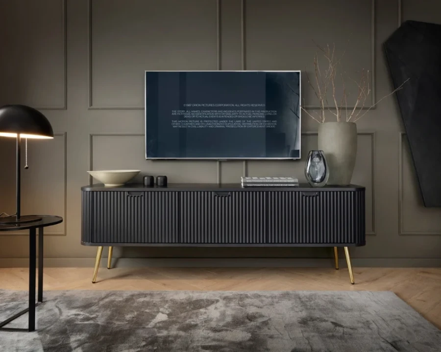 Schwarzes TV-Lowboard mit Akzenten durch goldene Beine in einer modernen Wohnzimmereinrichtung.