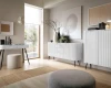 Modernes Wohnzimmer mit weißem, geriffeltem Sideboard und minimalistischer Einrichtung.