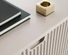 Detailansicht der geriffelten Oberfläche und Griffmulde eines beigen Sideboards.