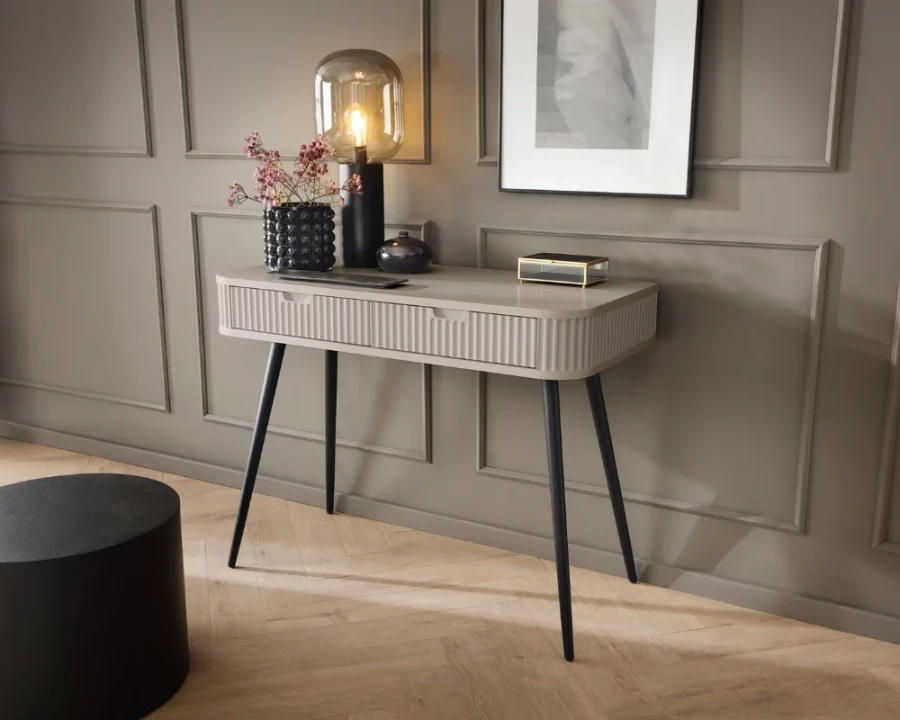 Beiger Konsolentisch mit Rillen-Design in elegantem Ambiente mit Parkettboden.