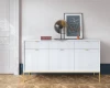 Weißes Sideboard mit geriffelter Front und goldenen Beinen im modernen Wohnzimmer.