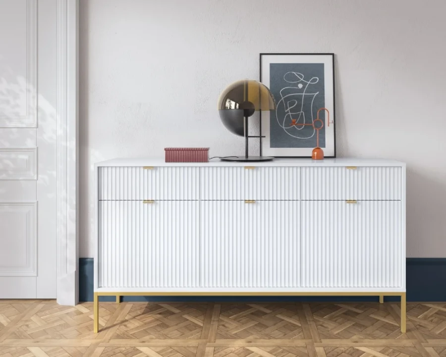 Weißes Sideboard mit geriffelter Front und goldenen Beinen im modernen Wohnzimmer.