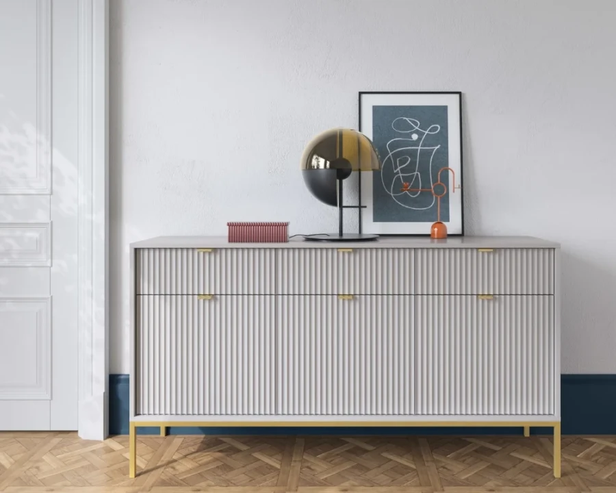 Dekoriertes Sideboard in Grau mit goldenen Akzenten auf einem klassischen Parkettboden.