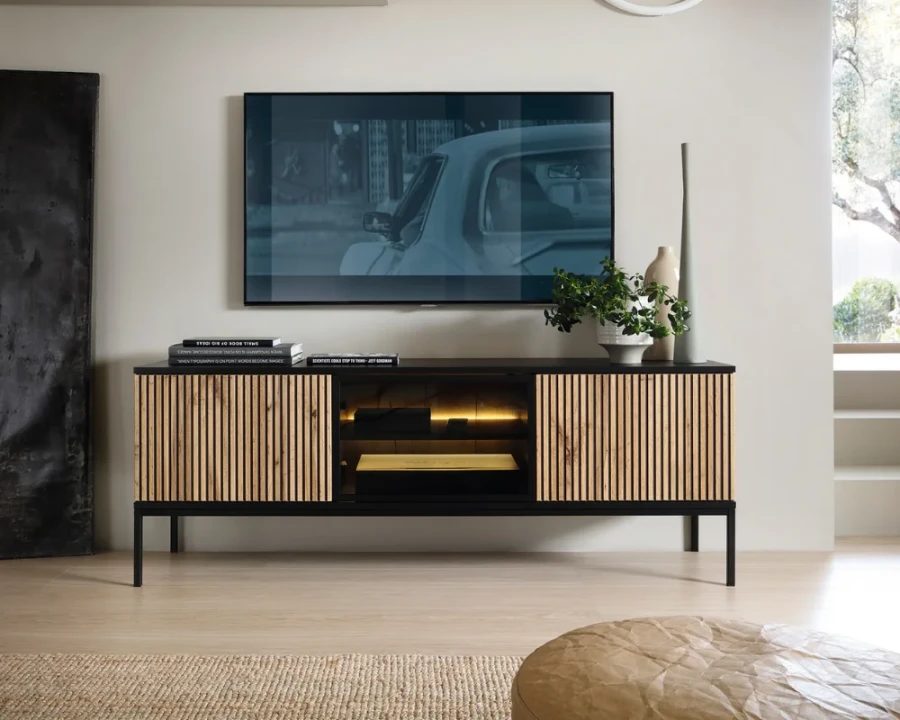 Stilvolles TV-Lowboard in Lamellen-Optik unter wandmontiertem Fernseher im Wohnzimmer.