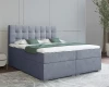 Blaues Boxspringbett mit gestepptem Kopfteil und grüner Decke für ein modernes Schlafzimmer.