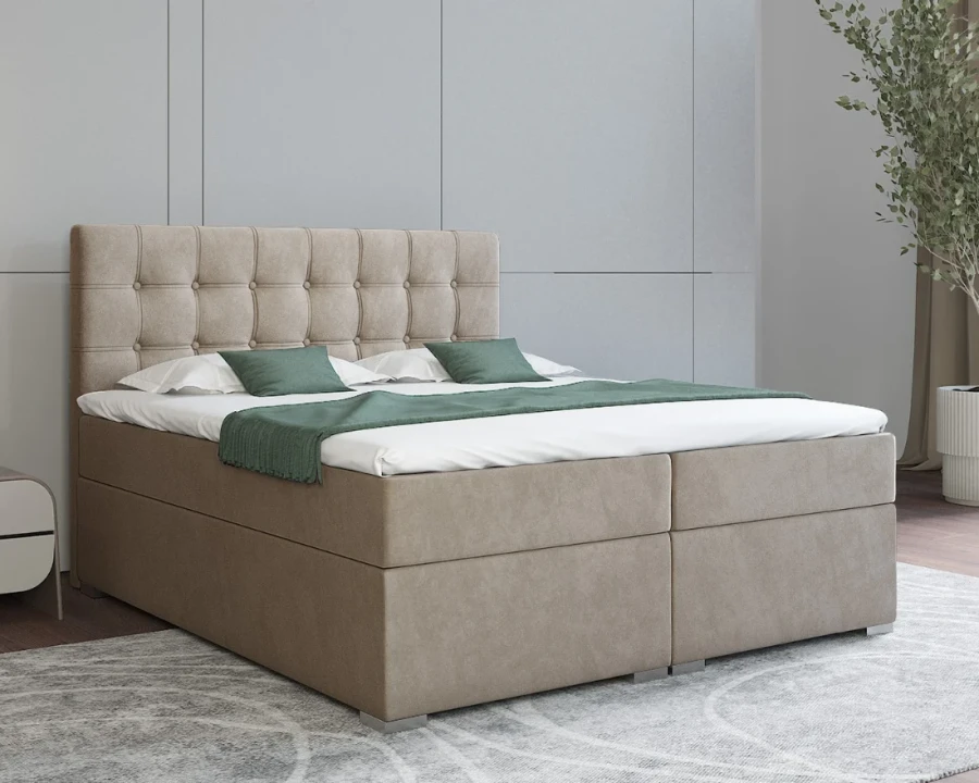 Beiges Boxspringbett mit eleganter Knopfheftung und grüner Tagesdecke im Schlafzimmer.