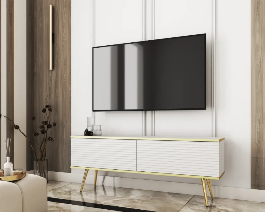 Weißes TV-Board mit Goldakzenten und Rillenmuster unter einem Wandfernseher.