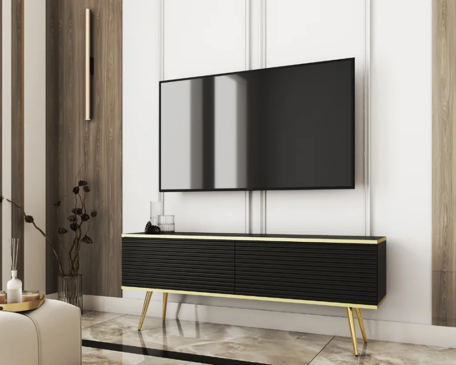 Schwarzes TV-Möbel mit goldenen Beinen und edler Rillenoptik im Wohnzimmer.