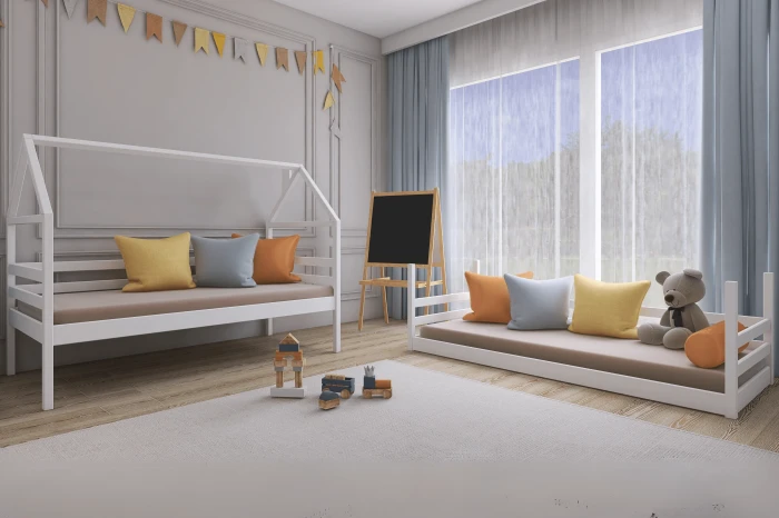 Modern eingerichtetes Kinderzimmer mit zwei weißen Hausbetten und Deko.