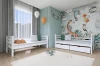 Children's room with two white beds, decorative giraffe wallpaper and toys for a cosy atmosphere.
