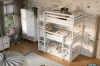Dreistöckiges Kinderbett in Weiß mit gemusterter Bettwäsche in einem verspielten Kinderzimmer.