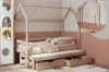 Holz-Hausbett für Kinder mit zusätzlichem Ausziehbett und zwei Schubladen in gemütlichem Zimmer.