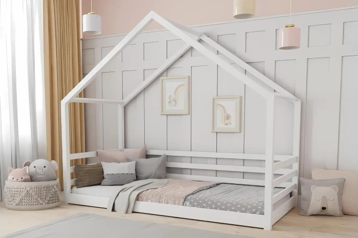 Weißes Kinderhausbett aus Holz in einem hellen, modern eingerichteten Kinderzimmer.